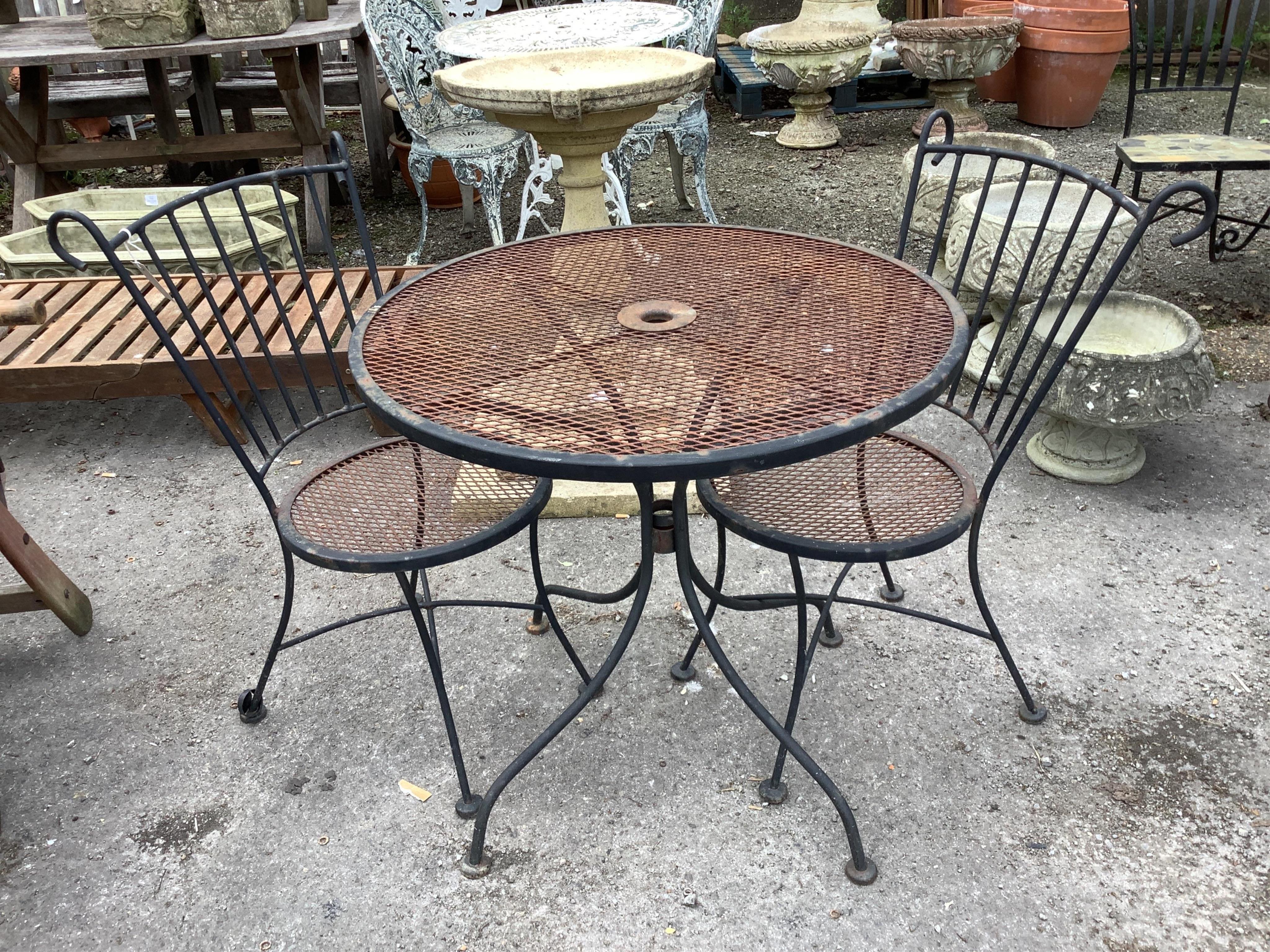 A wrought iron circular garden table, diameter 78cm, height 71cm together with a pair of matching chairs
